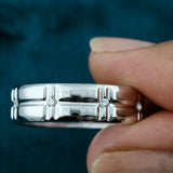 Classic Wedding Band Held Between Fingers 