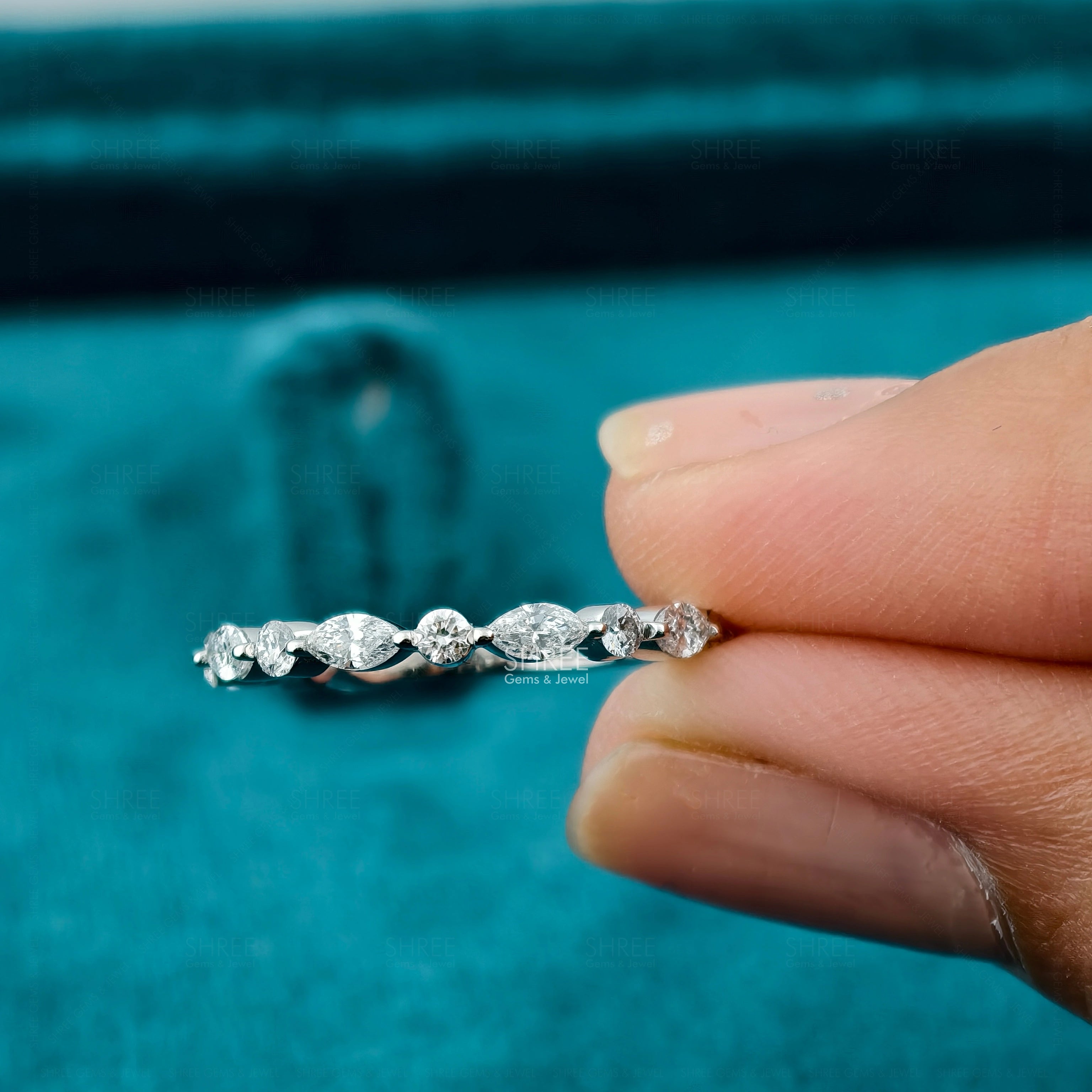 In hand view of Marquise and Round Diamond Eternity Ring​